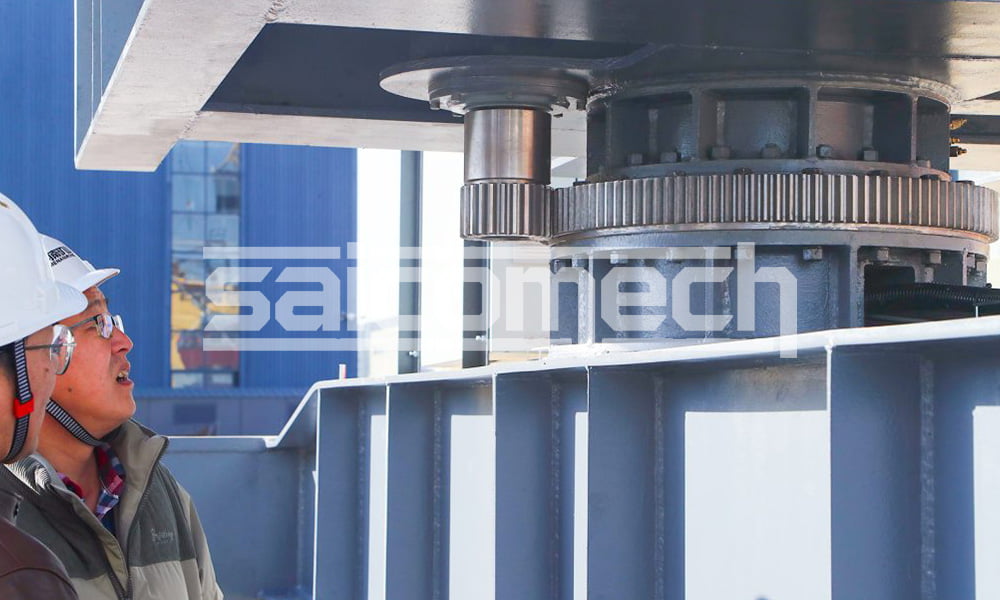 Crane mechanical assembly inspected by a worker